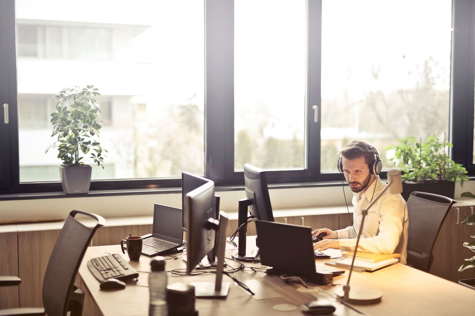 Truck dispatcher wearing a headset working at a multi-screen desk