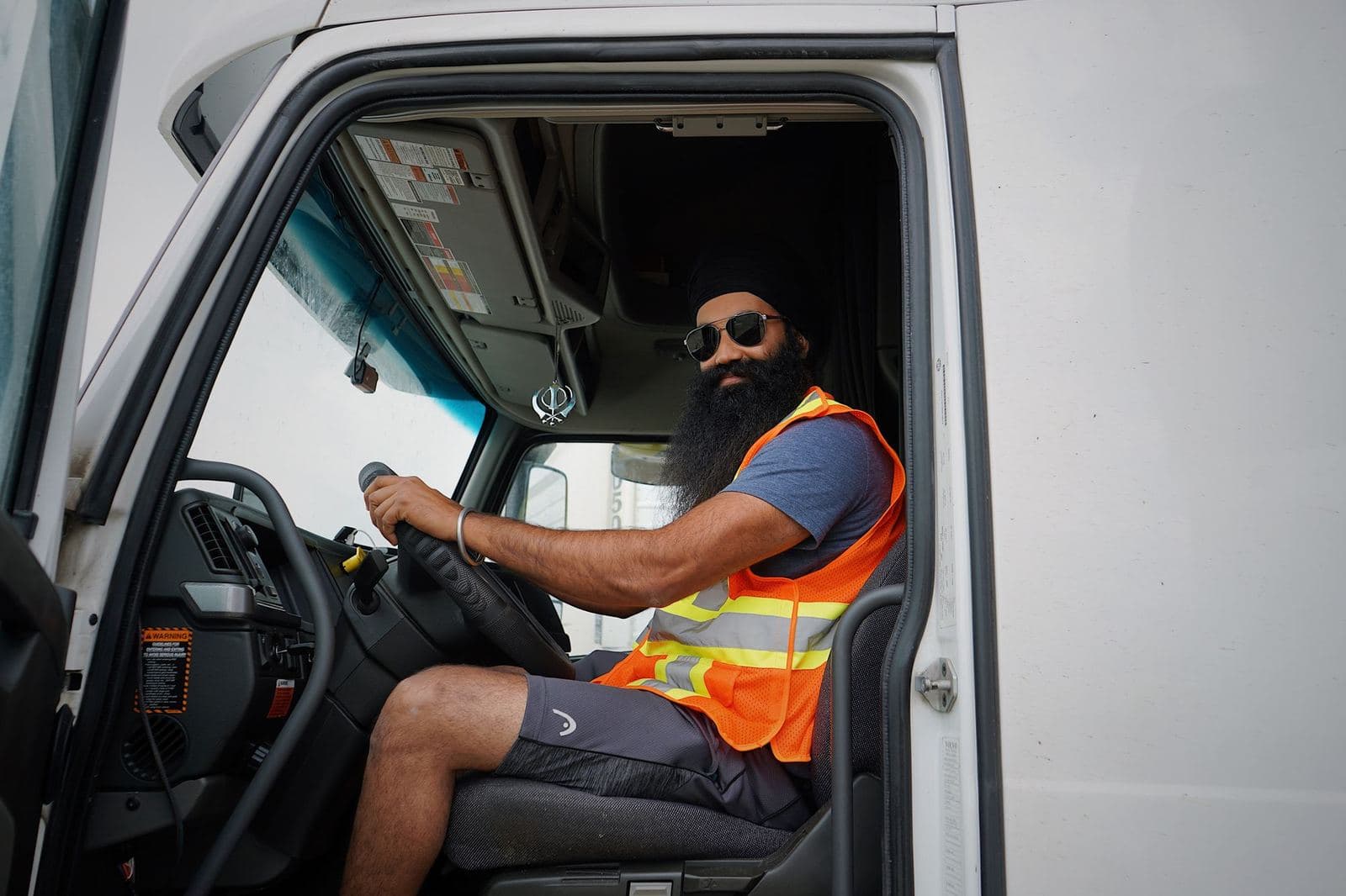 Owner-operator smiling from the driver's seat of his truck